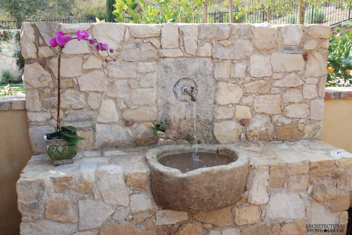 Fuente de piedra en la pared del jardín